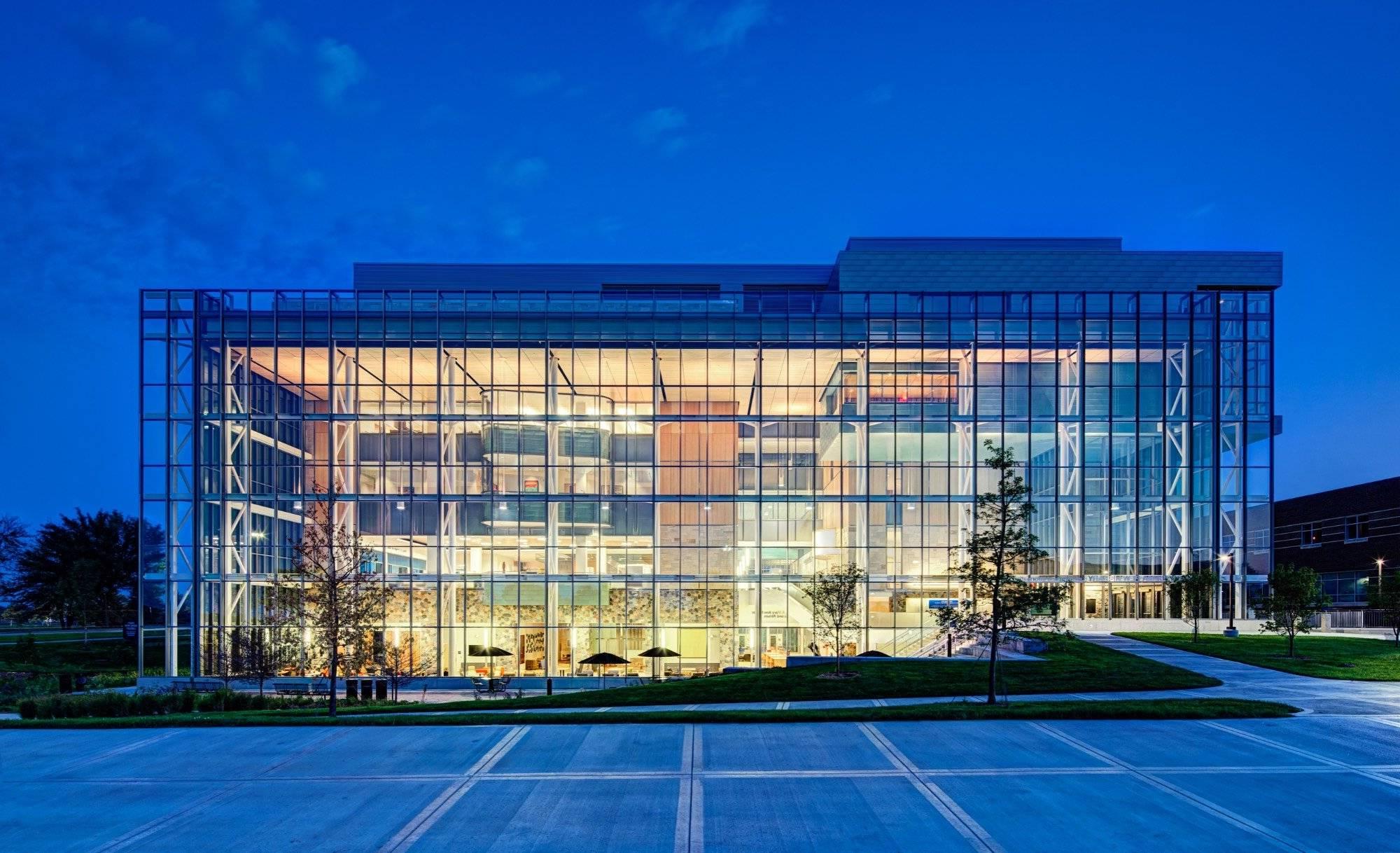 Mary Idema Pew library lit up at night with a glowing wall of windows